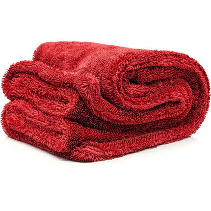Sukací ručník z froté, červený, srolovaný do válce.