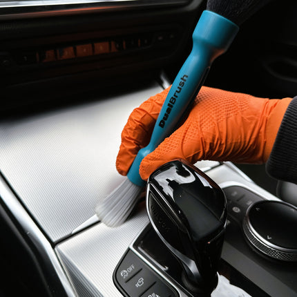Dvojitý štětec DualBrush v oranžových rukavicích čistí středový panel bílými štětinami