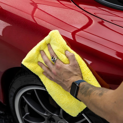 Mikrovláknový sušící ručník Auto Finesse Primo, žlutý s černým lemem, přiložený k povrchu