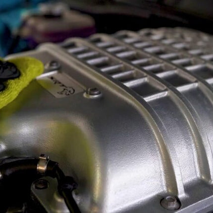 Univerzální čistič při čištění motoru v rukavici a zelené utěrce