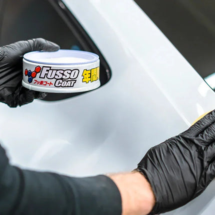 Přípravek Fusso Coat: plechovka v rukavicích a žlutá houba na autolak
