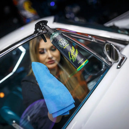 Čistič oken v rozprašovači, aplikace na autosklo s modrým hadříkem
