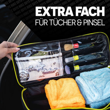 Otevřená černá taška na detailing se zipovým pouzdrem, štětci a utěrkami