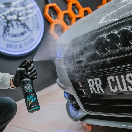 Lahev detaileru při aplikaci na přední část auta u světlometu