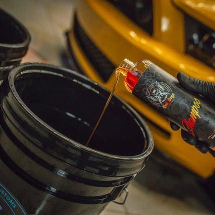 Autošampon v lahvi vedle kbelíku a mycího nářadí